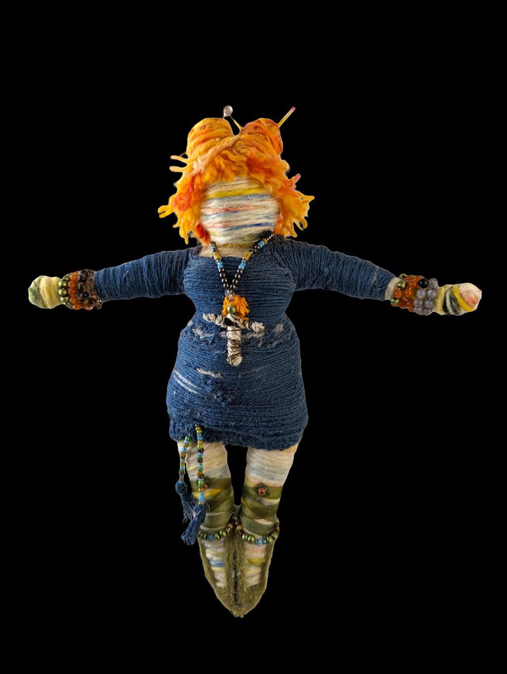 Front view of the custom "Butterfly" You-Do-You Voodoo™ art doll with orange and yellow hair, a blue long sweatshirt, green ballerina-style shoes, and various jewelry including a small voodoo doll necklace, bracelets, a decorative hairpin, and two pencils holding her double top-knots in place.