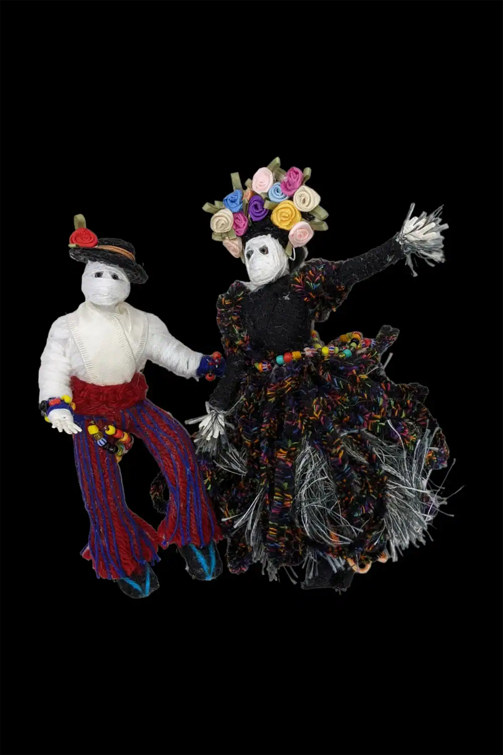 Handmade Day of the Dead skeleton dolls, a male and female couple, adorned with vibrant floral decorations.