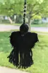 Back view of the Plague Doctor Charm showing the hood trimmed with an obsidian bead and detailed yarn cloak.
