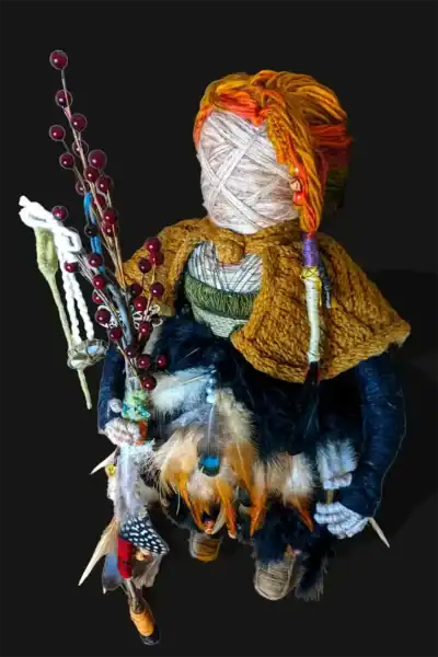 Close-up of Ella the forest spirit art doll's top-left side, showing her detailed cloak, feathered dress, and intricately wrapped braid in her multicolored hair.