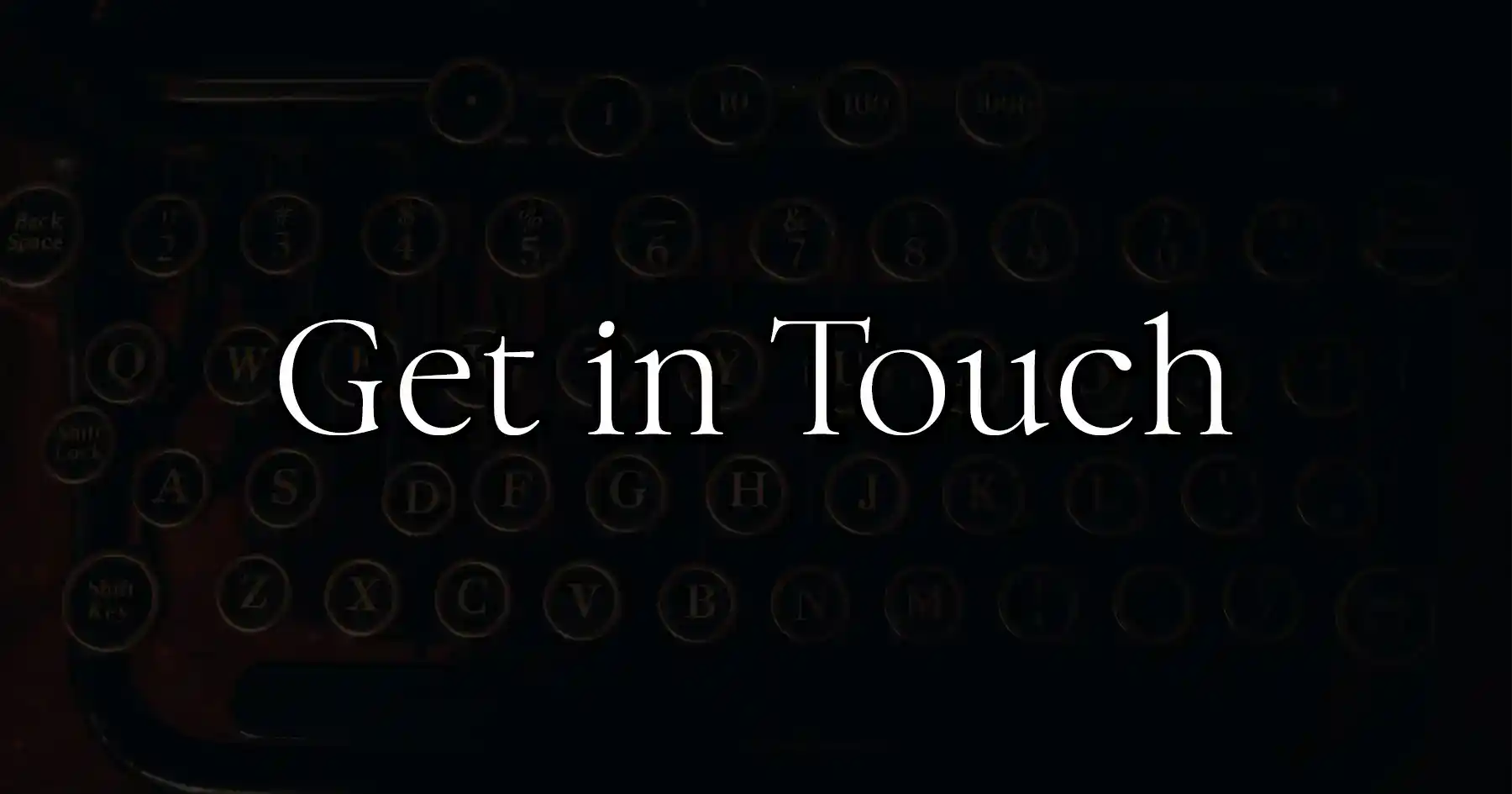 Dark image with typewriter in the back that says "Get in Touch".