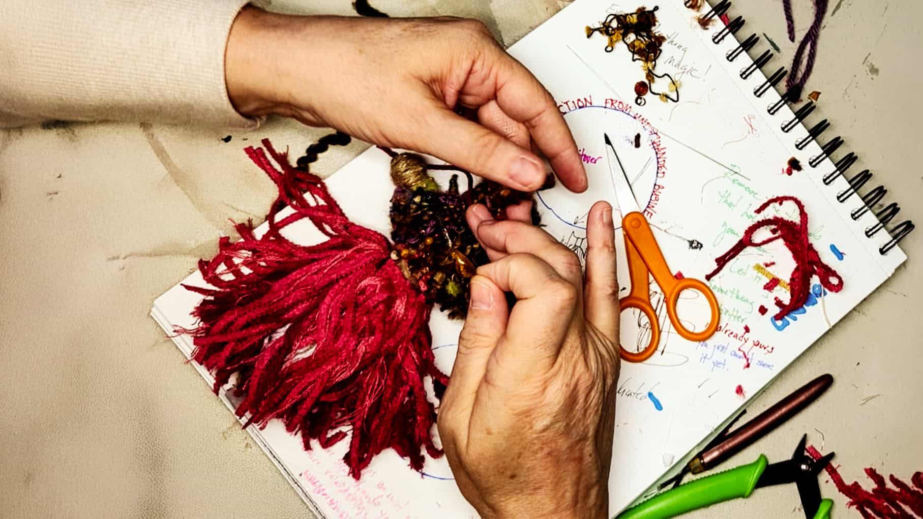 Intricate fiber art project with colorful yarns and crafting tools, showcasing creative textile techniques.