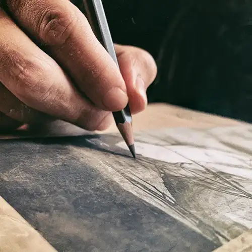 Close-up of a hand sketching loose, expressive pencil lines on textured paper