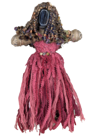 Handmade art doll with braided yarn hair, a stone face, copper wire coils, beaded belt, and a fringed pink yarn dress